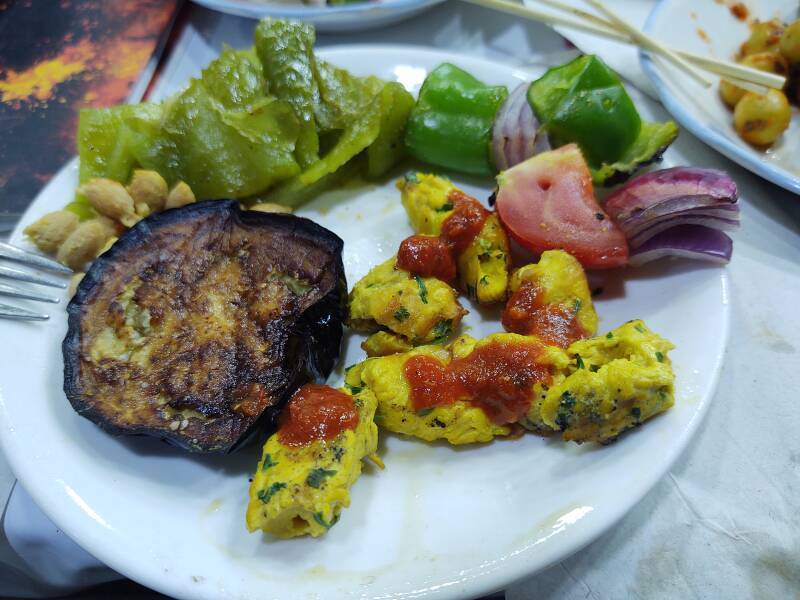 ALT: Grilled eggplant, peppers, spicy chicken, onions, and tomatoes; dinner at a food stall on Sāḥat Jāmi' al-Fanā', or The Mosque at the End of the World, in central Marrakech.