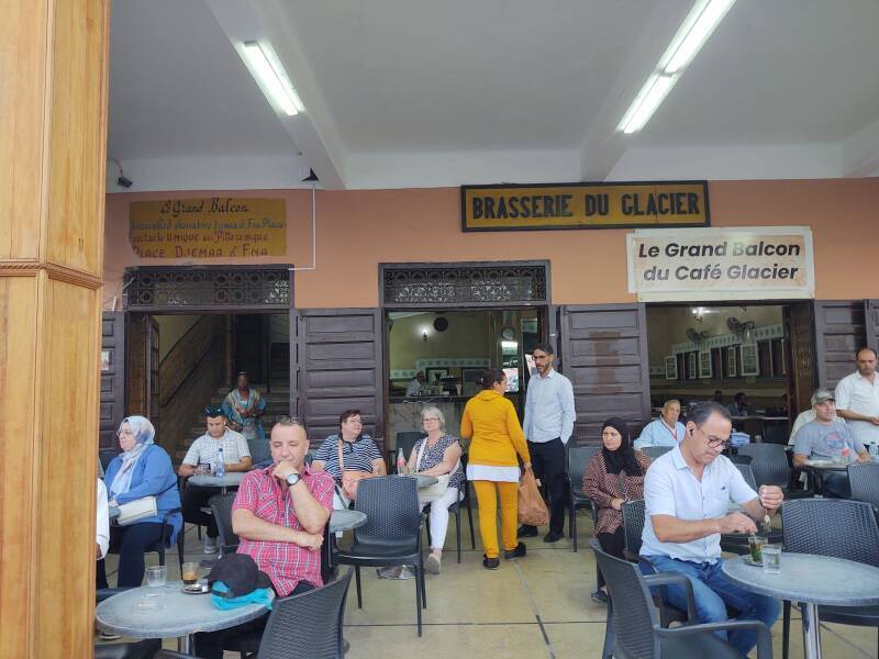 Patrons on the veranda of Brasserie du Café Glacier on the south side of the open square of Sāḥat Jāmi' al-Fanā', or The Mosque at the End of the World, in central Marrakech.