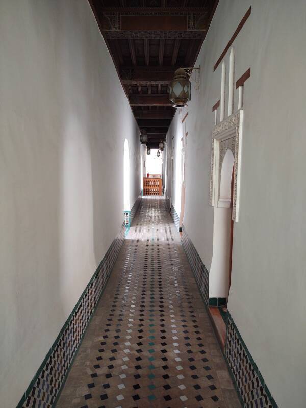 View down a hallway past student room upstairs in the Ben Youssef madrasa in the medina of Marrakech.