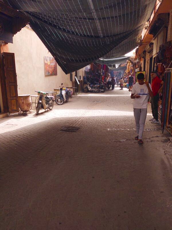 Man walking under a fabric souq cover in the medina in Marrakech.