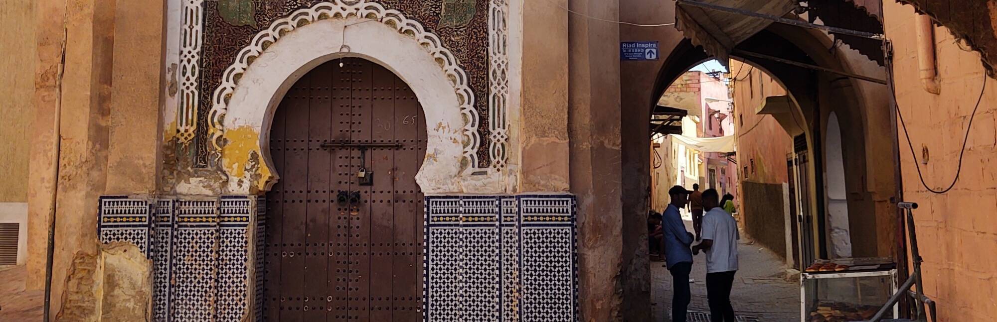 Two men speak in a narrow lane in the medina of Meknès.