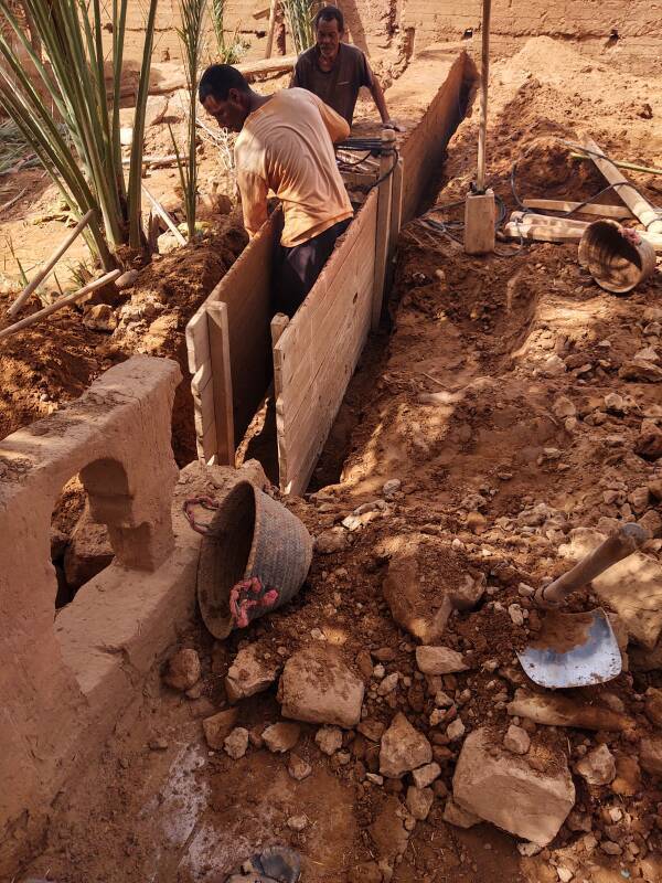Two men building an rammed-earth wall at Auberge La Palmeraie.