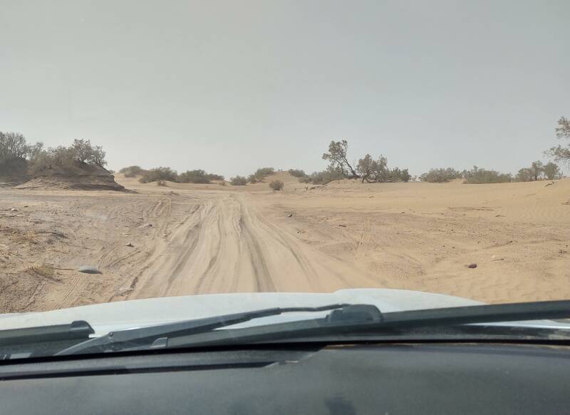 Looking out through the windshield at the sandy track in the desert outside M'Hamid.