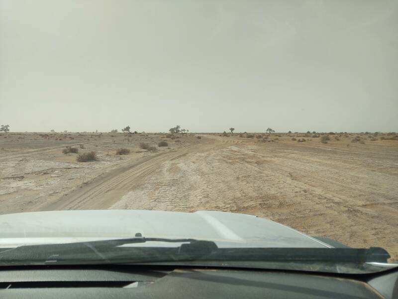 Looking out through the windshield at the sandy track in the desert outside M'Hamid.