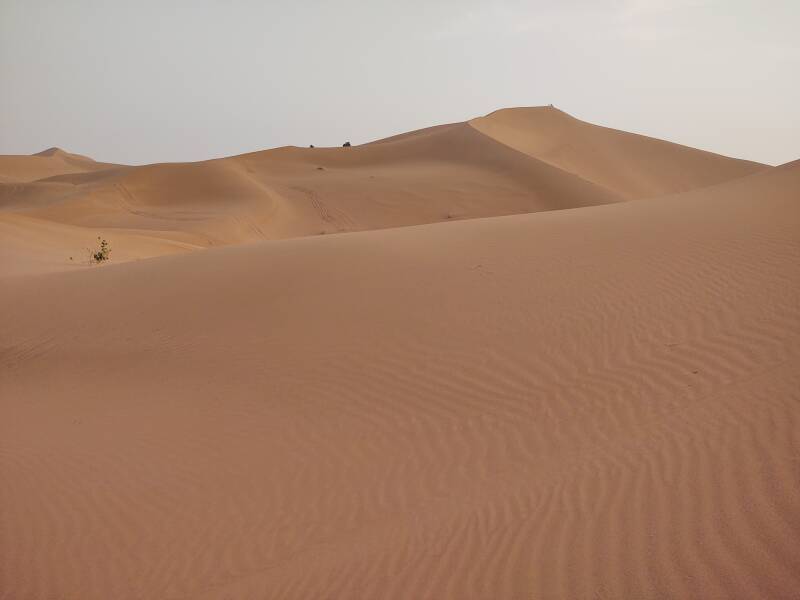 People on top of a 150-meter dune in the distance.