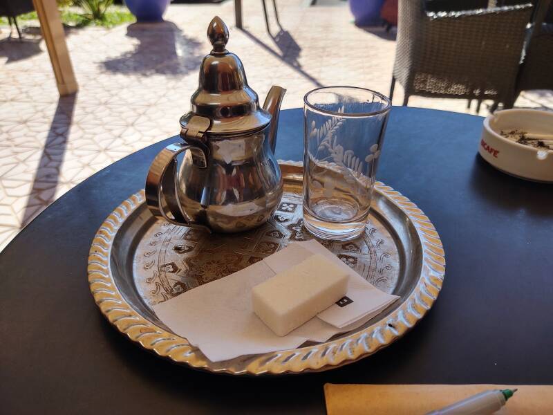 Shiny tea pot, small glass, and large block of sugar for mint tea before boarding the bus from Marrakech to Zagora.