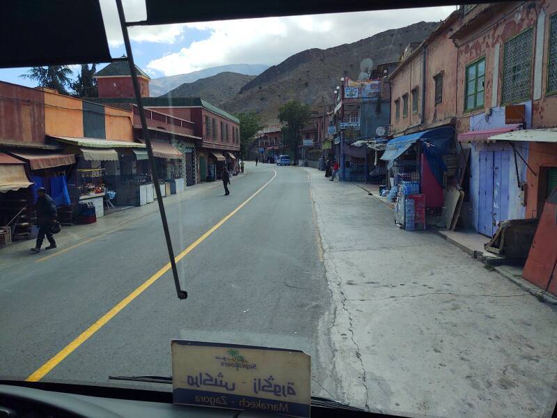 A man crosses the highway. Businesses line the road through Taddart Izdar in the Atlas Mountains.