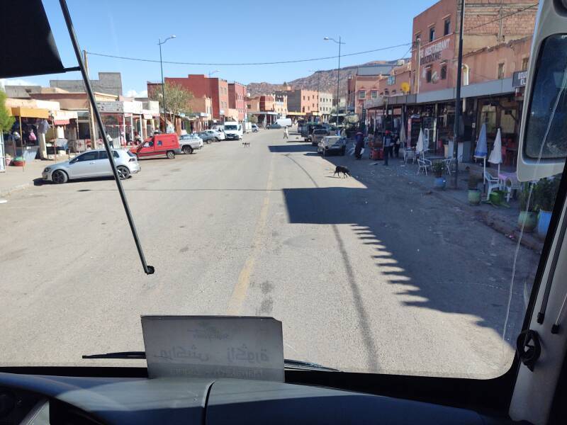 Businesses along the road in Agouim in the Atlas Mountains. Two dogs cross the road.