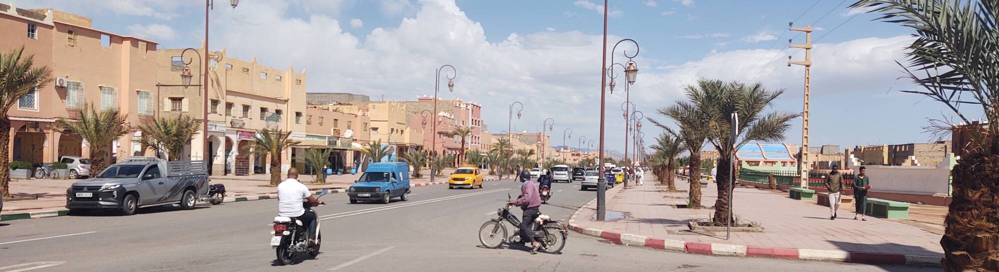 Motorcycle, scooter, and car traffic on the highway through through the center of Zagora.