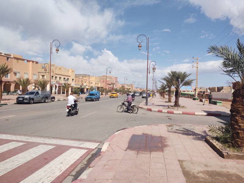 Motorcycles, scooters, and cars on the N9 highway through Zagora, Morocco.