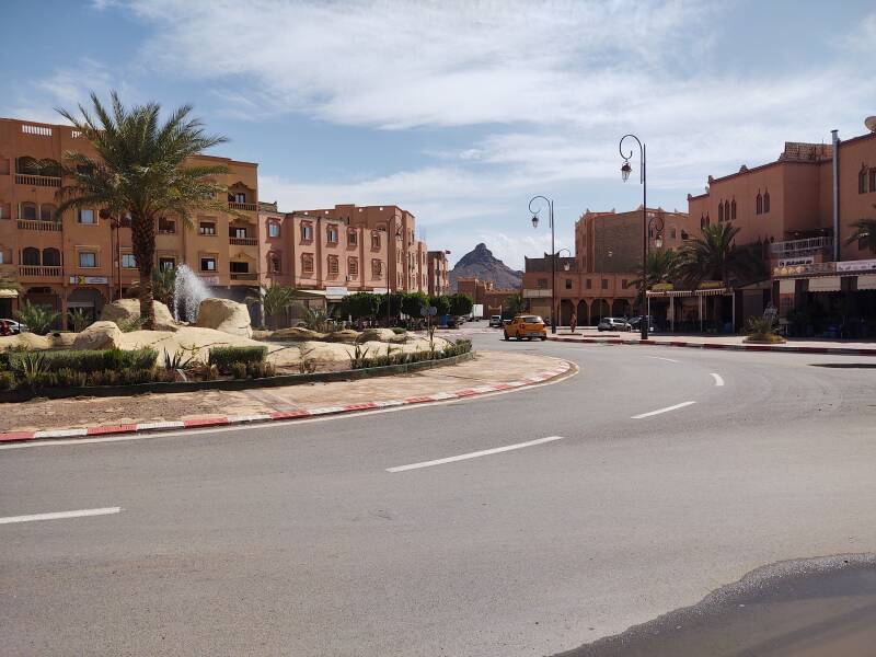 Traffic circle on the N9 highway passing through Zagora, Morocco, with a view of Jebel Zagora in the distance.