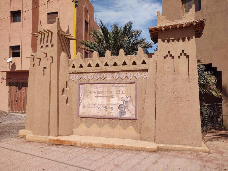 'Tombouctou 52 Jours' sign, indicating the start of the 52-day trek across the Sahara from Zagora to Timbuktu.