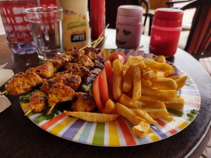 Chicken kebab, french fries, and salad in Zagora, Morocco.