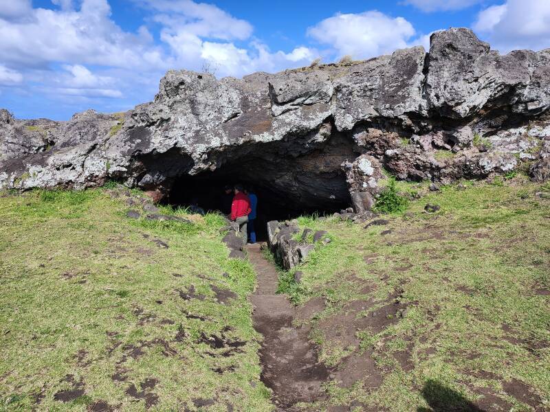 Path leading into a cave beneath a layer of rock.