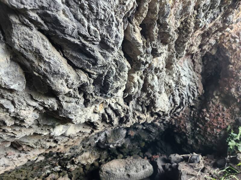 Closeup of cave ceiling consisting of thin twisted layers of frozen lava.