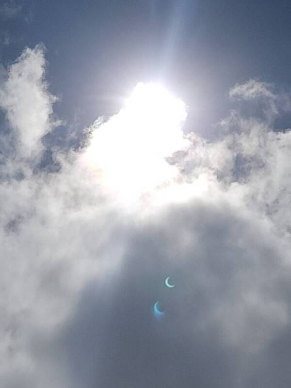 Crop of partial phase of annular solar eclipse with crescent lens flares, seen in Hanga Roa, Rapa Nui.