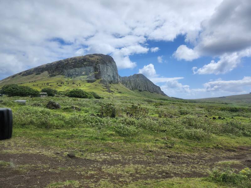 Mo'ai on the green grass slopes below the upper cone of Rano Raraku.