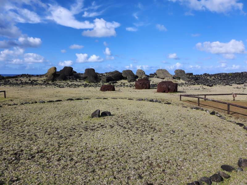 Toppled mo'ai, three loose pukao or topknots made from red volcanic scoria.