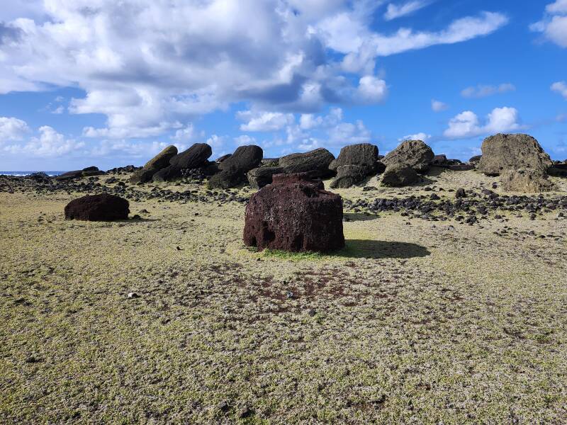 Toppled mo'ai, loose pukao or topknots made from red volcanic scoria.