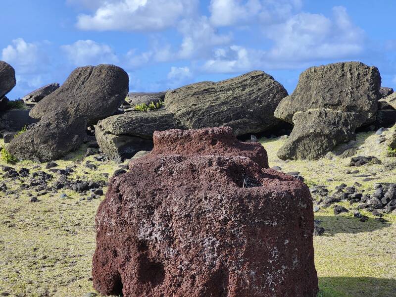 Toppled mo'ai, loose pukao or topknots made from red volcanic scoria.