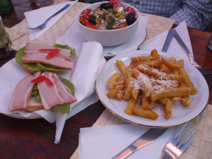 Romanian mixed salad, sandwiches and french fried potatoes.