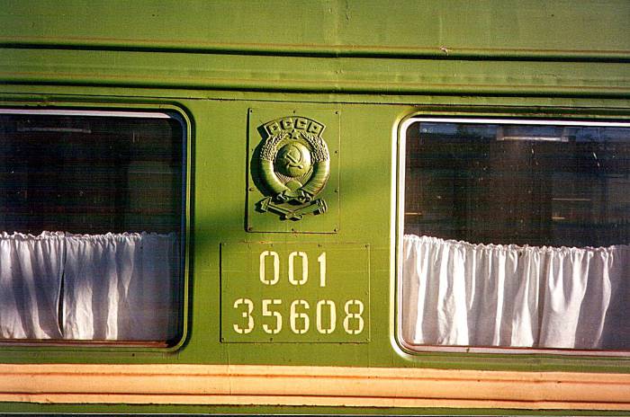 Exterior of a Russian passenger train car with СССП plate and filmy white curtains.