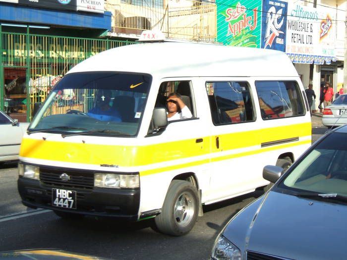 A brightly colored maxi-taxi (or shared van) in Trinidad.  This one is almost full, many people are inside.