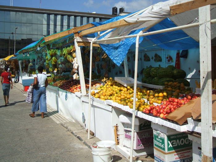 Downtown Port-of-Spain, Trinidad. Lots of brightly colored fruit for sale in the market: Oranges, mangoes, papayas.