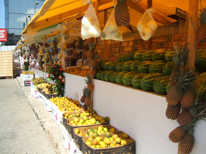 Downtown Port-of-Spain, Trinidad. Lots of brightly colored fruit for sale in the market: Lemons, watermelons, pineapples, oranges, mangoes.