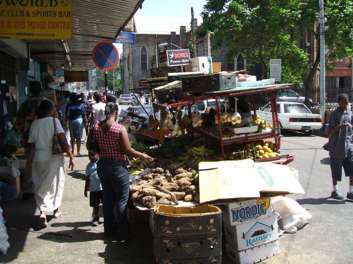 Downtown Port-of-Spain, Trinidad. Markets along the sidewalk with sweet potatoes and other produce.