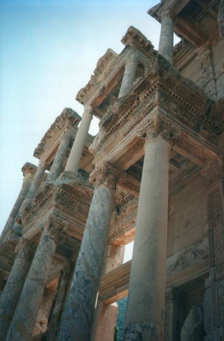 Ephesus: the Library of Celsus.  Looking up at Corinthian columns supporting porticos on the marble facade.  Smooth concrete shows where the archaeologists have restored the columns.