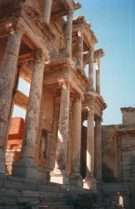 Ephesus: the Library of Celsus.  Looking up at Corinthian columns supporting porticos on the marble facade.  Smooth concrete shows where the archaeologists have restored the columns.