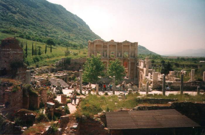 Ephesus: the Library of Celsus and the city center.  Ruined buildings, a restored row of columns, and the facade of the library structure.