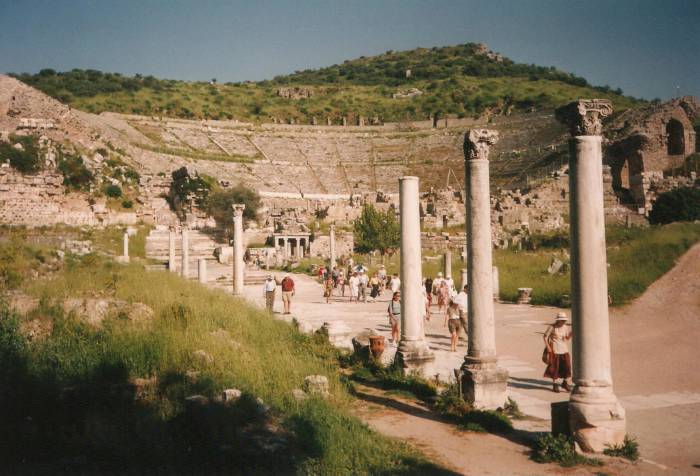 Ephesus: the Great Theatre.  A group of visitors walks past a row of Corinthian columns.