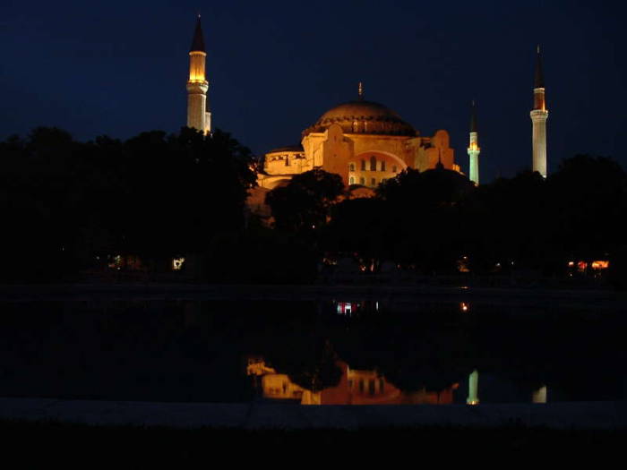 Exterior of the Hagia Sophia or Aya Sofya, in Istanbul.  Night time view.  Four large minarets around a large dome.