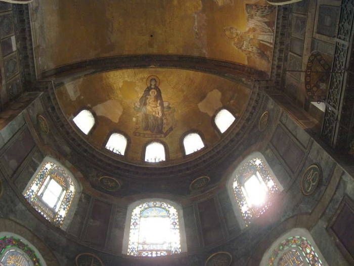 Interior of the Hagia Sophia or Aya Sofya, in Istanbul.  Mosaic of the Virgin Mary and Jesus in a large semi-dome, stained glass windows below.