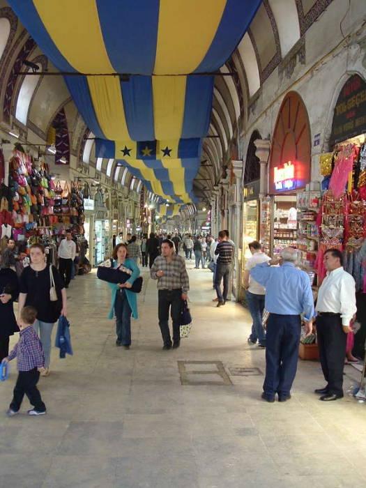 Interior of the Grand Bazaar in Istanbul.  Indoor street lined with shops, stone archways and domes.