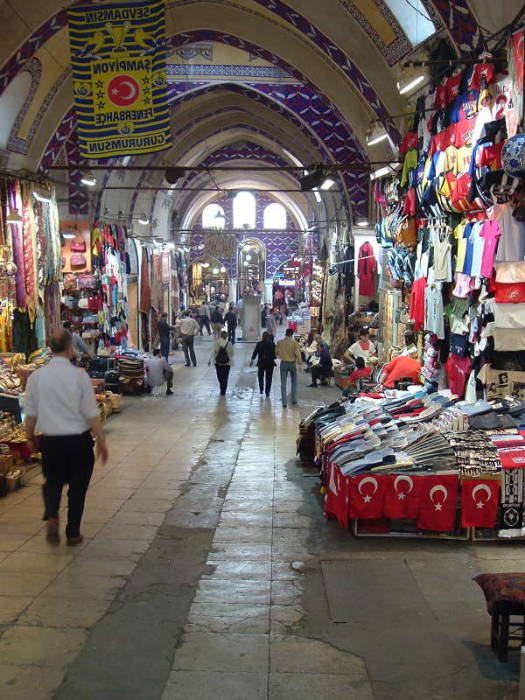 Interior of the Grand Bazaar in Istanbul.  Indoor street lined with shops, stone archways and domes.
