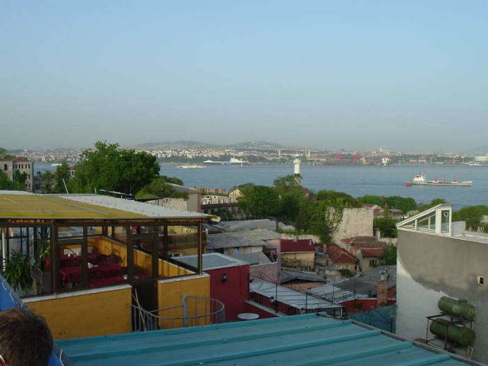 A view across the Bosphorus in Istanbul, from the Sultanahmet district to the Asian shore.  A cargo ship is passing through the Bosphorus, beyond the lighthouse.