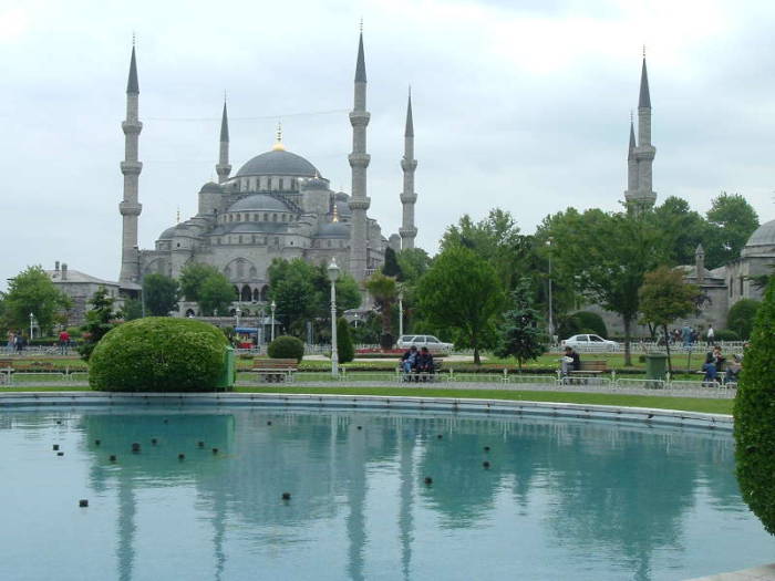 Blue mosque or Sultanahmet Cami, in Istanbul, with its six minarets and many domes.  Daytime view with reflecting pool.