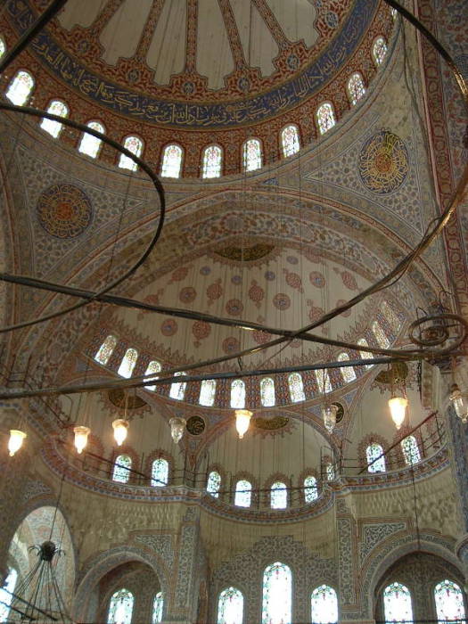 Interior of the Blue mosque or Sultanahmet Cami, in Istanbul.  Many domes and beautiful tile walls.