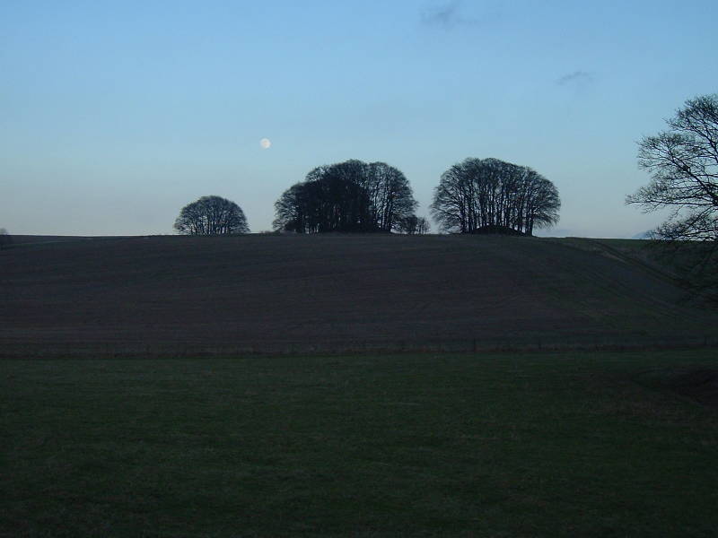 The full Moon rists over tumuli near The Sanctuary and Avebury.
