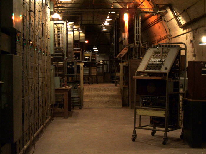 Large racks of signal repeating equipment, electronic test equipment.