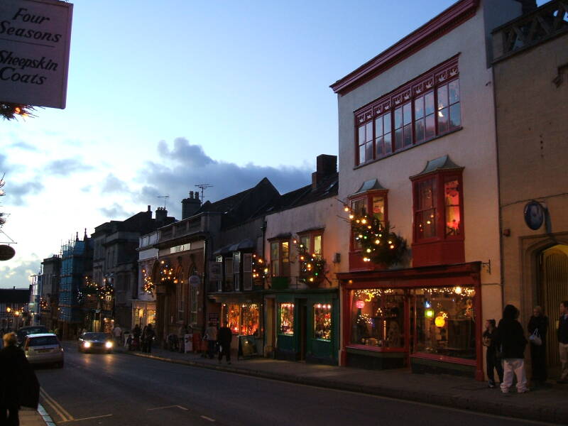 High Street shops are lit in the early evening just before Christmas.