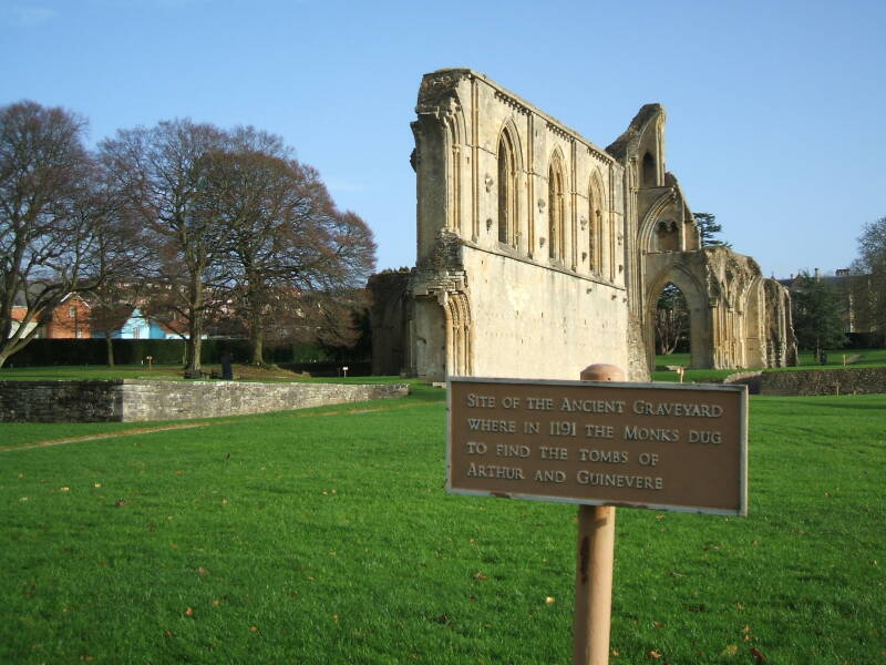 South exterior of Glastonbury Abbey and sign marking one of the graves of King Arthur.