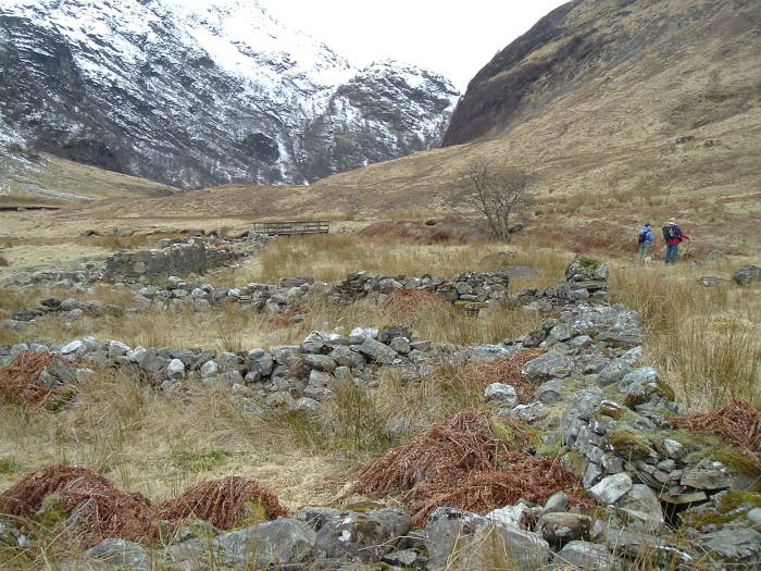 Hikers exploring the ruins of the abandoned settlement of Steall, above Glen Nevis in Scotland.