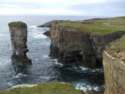 Geos and freestanding stone pillars along the sea cliffs of the west coast of Orkney.