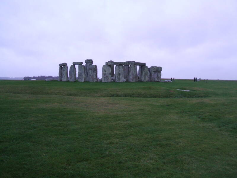 People visiting Stonehenge in the rain.