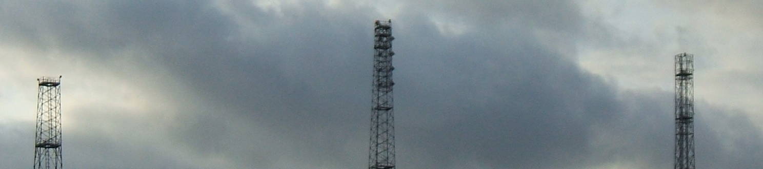 Towers of the Swingate Chain Home radar site stand before the clouds.