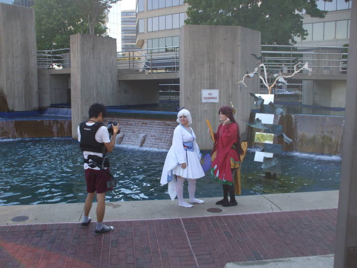 Anime girls being photographed at a fountain at the Otakon anime and manga conference in Baltimore.